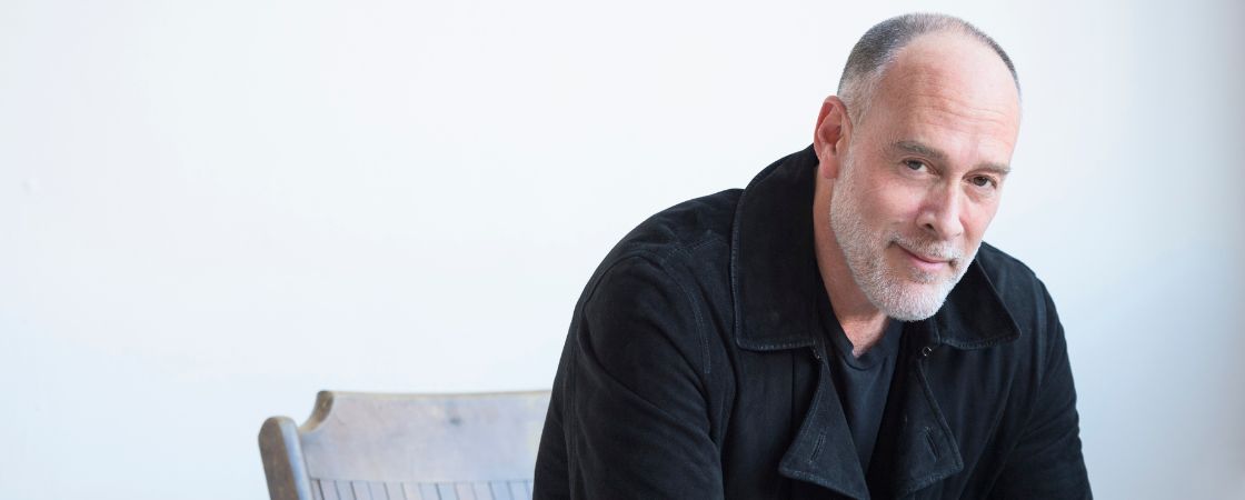 Marc Cohn sitting on a chair and smiling