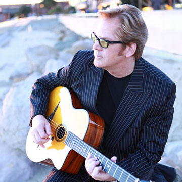 man looking off with guitar