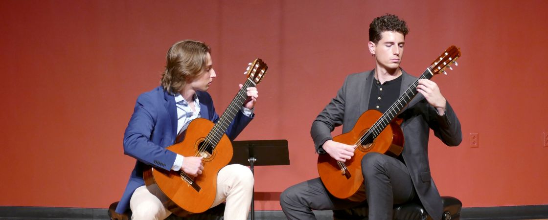 two men playing classical guitar