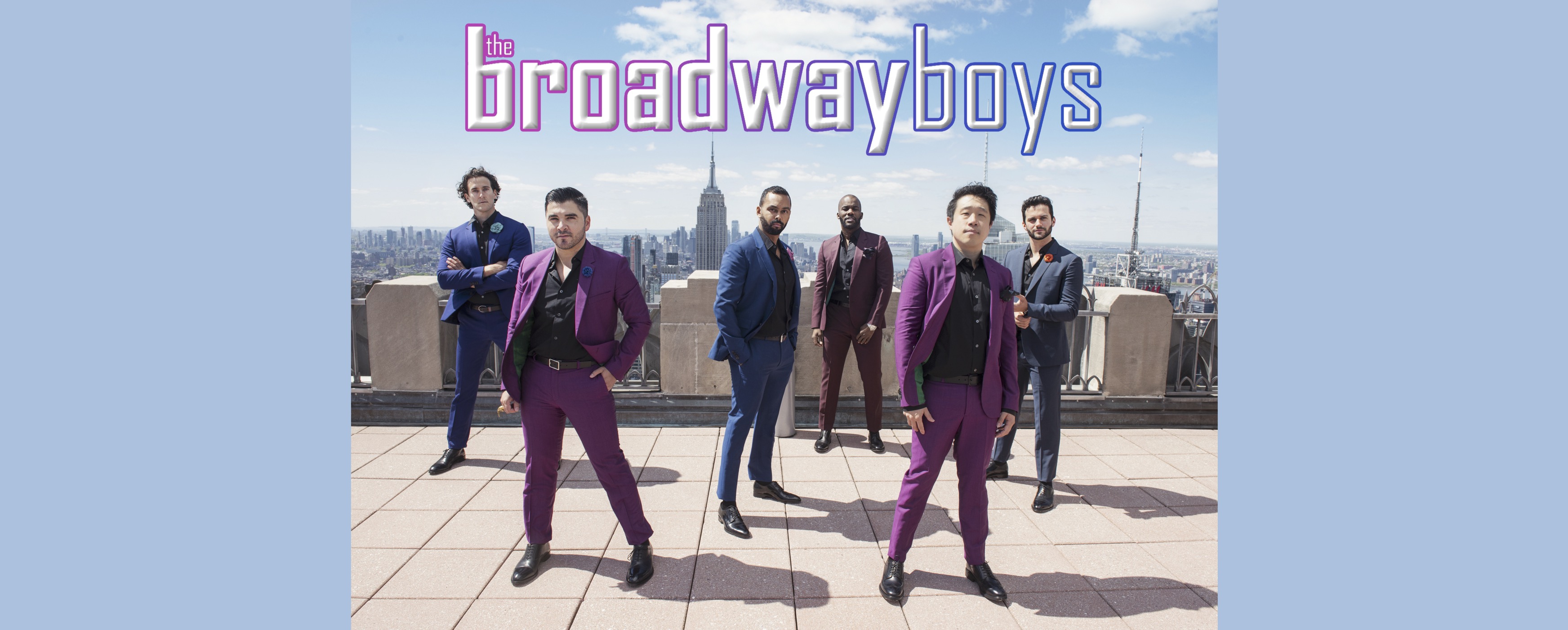 image of the Broadway Boys in suits on a New York City rooftop with New York City skyline in the background