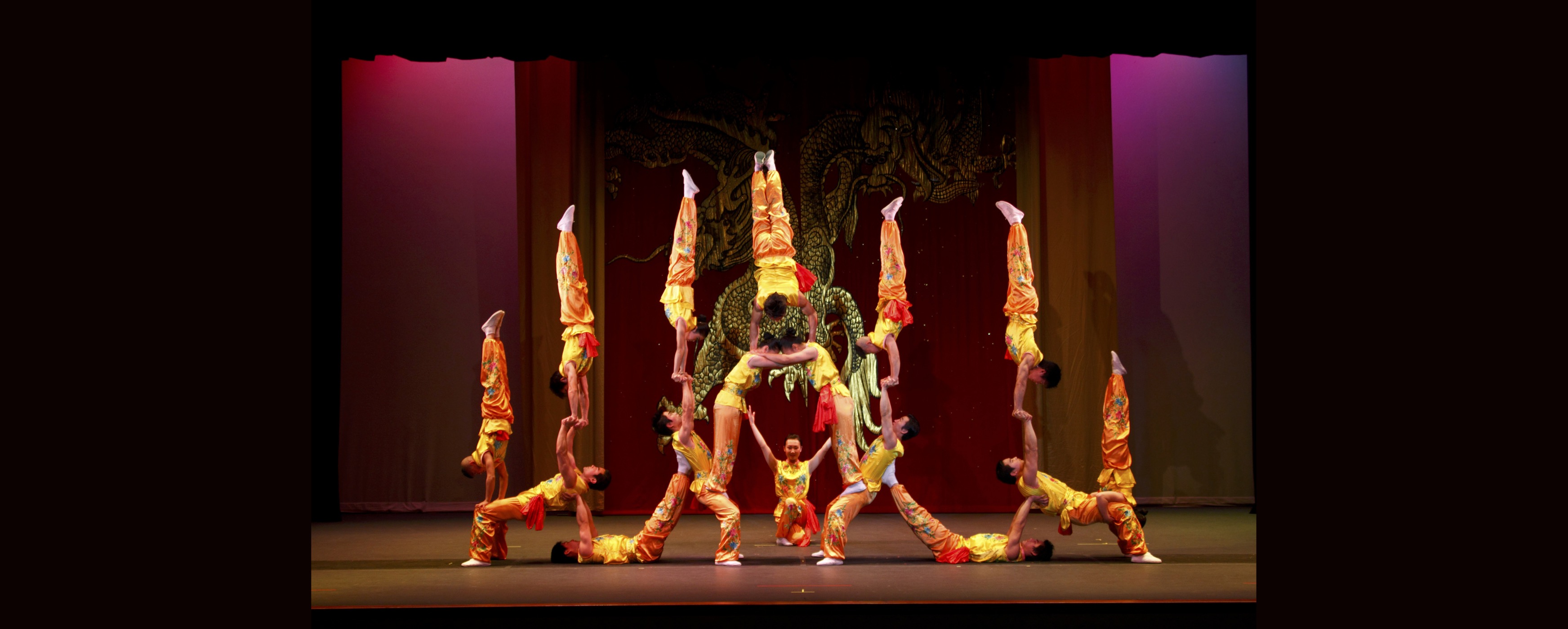 Image of acrobats creating a human pyramid or tower structure onstage