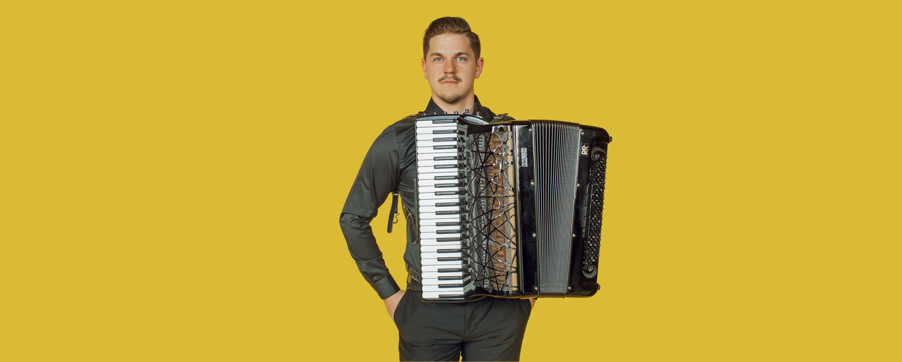 Image of Radu Ratoi holding accordion on yellow background