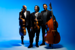 Simply Three pose with their instruments on a blue background