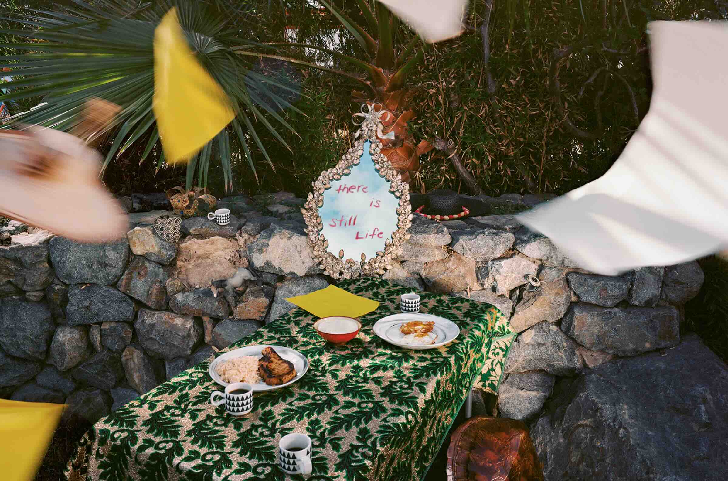 image of table with food and a mirror that has "there is still life" written on it